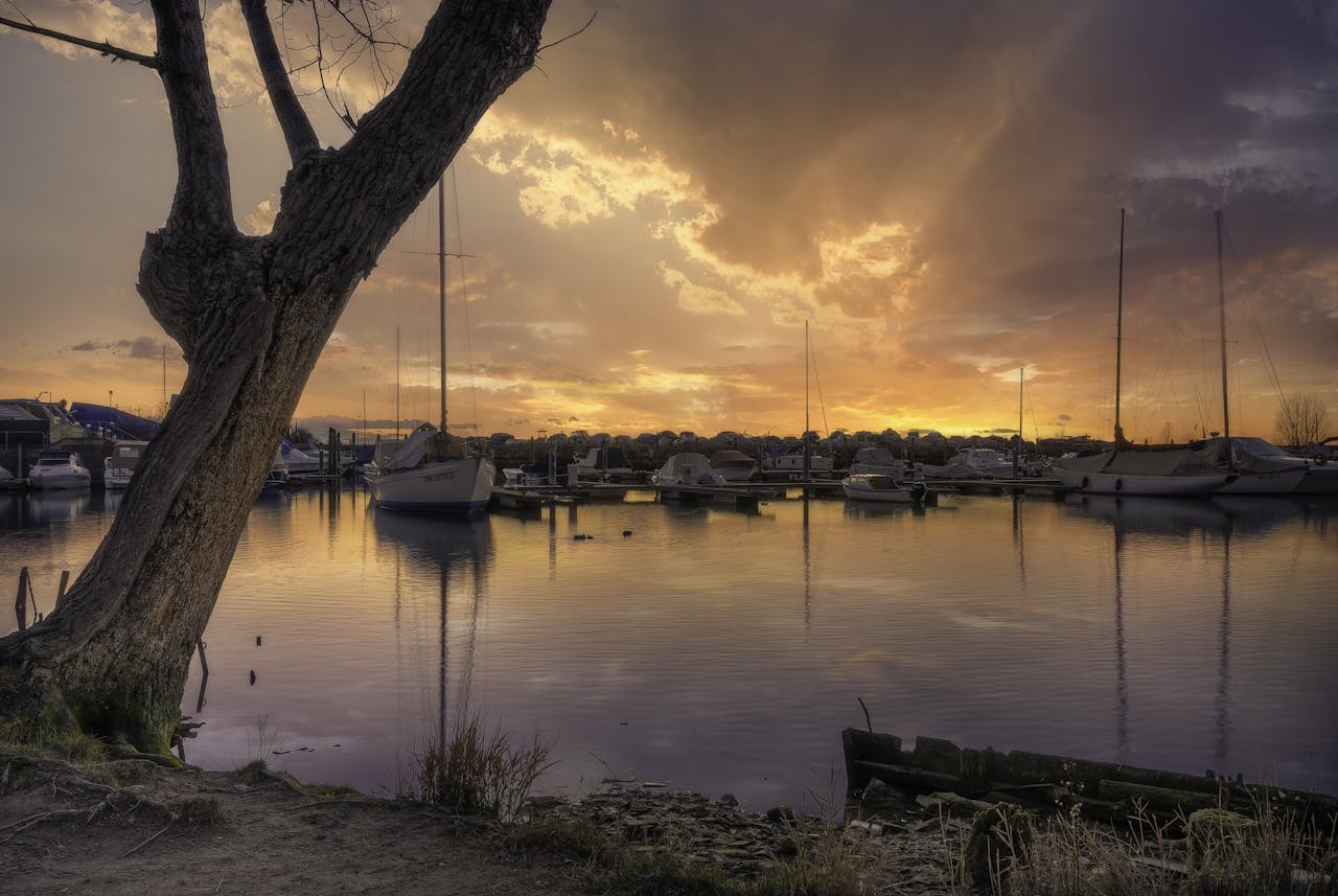 ours-journey A tranquil view of boats docked at a Venetian marina against a stunning sunset backdrop.